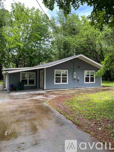 A house with a grey roof and a driveway in front of it.
