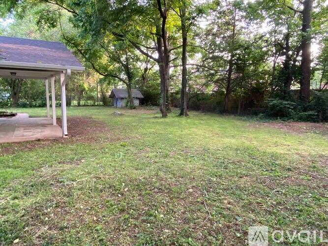 A backyard with a gazebo and trees.