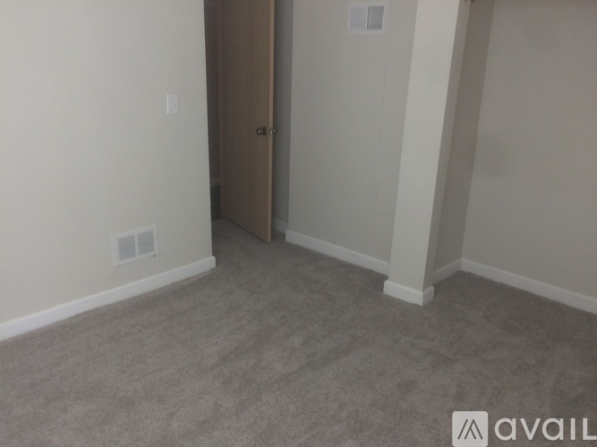 A room with a carpeted floor and a closed door.
