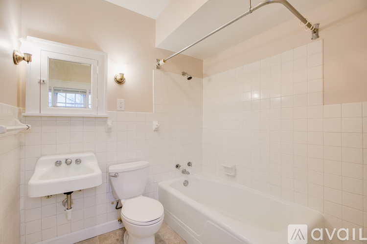 A white bathroom with a tub, toilet, and sink.