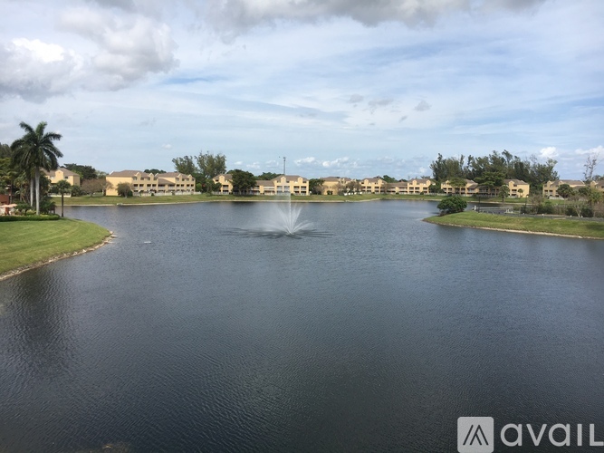A large body of water with a fountain in the middle and buildings in the background.