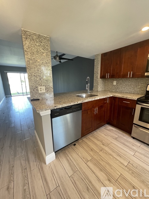 A kitchen with wooden cabinets and a granite countertop.