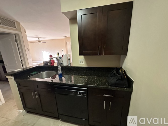 A kitchen with black cabinets and a black countertop.