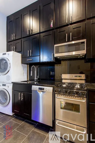 A kitchen with black cabinets and stainless steel appliances.