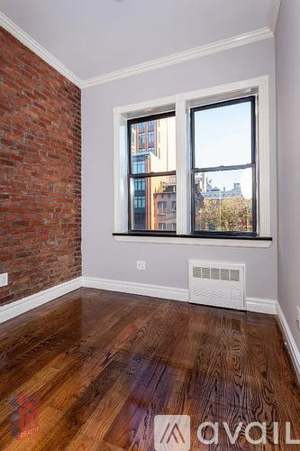 A room with a brick wall and a window.