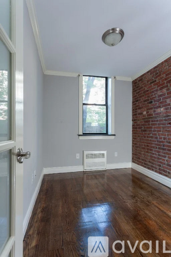 A room with a wooden floor and a window.