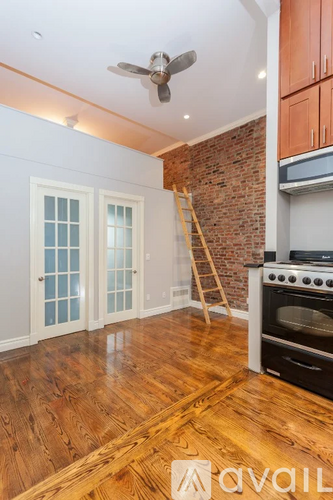 A room with a brick wall and wooden floors.