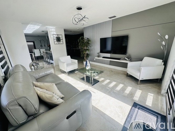 A living room with a grey couch and a glass coffee table.