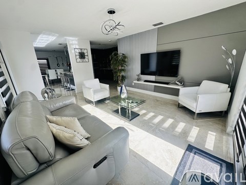 A living room with a grey couch and a glass coffee table.