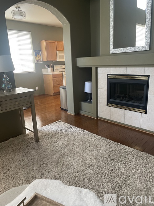 A living room with a fireplace and a rug on the floor.