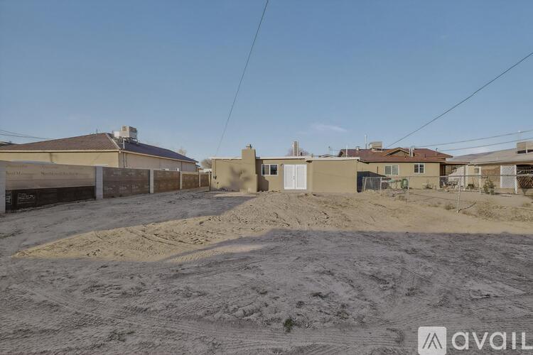 A sandy area with a building in the background and a sign that says "available".