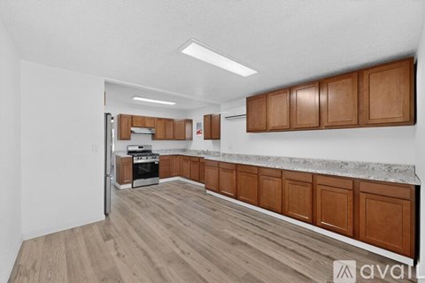 A kitchen with wooden cabinets and a marble countertop.
