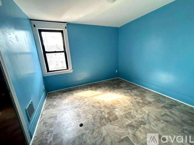 A room with a window and tiled floor.