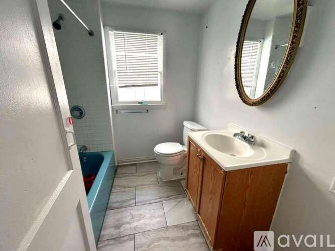 A bathroom with a toilet, sink, and bathtub.