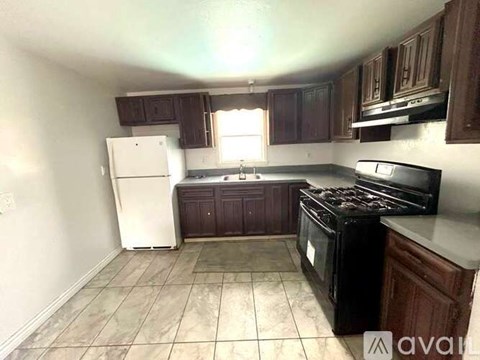 A kitchen with a black stove top oven and a white refrigerator.