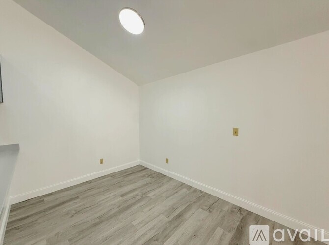 A room with a wooden floor and white walls.
