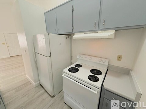 A kitchen with a white fridge and stove top oven.