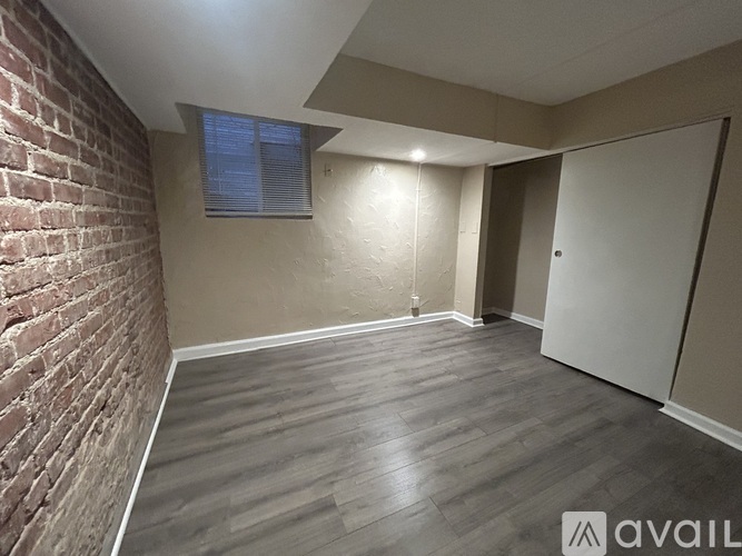 A room with a brick wall and wooden flooring.