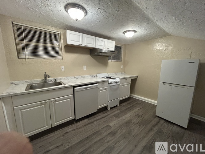 A kitchen with white appliances and cabinets.