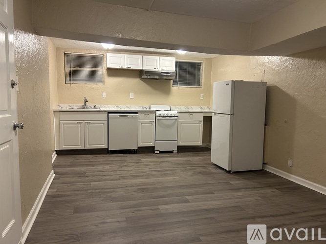 A kitchen area with white appliances and cabinets.