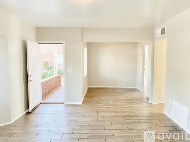 A spacious room with a tiled floor and a doorway leading to a balcony.