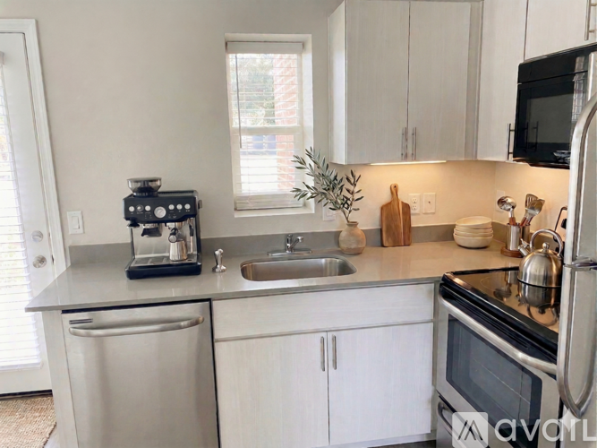 A white kitchen with a black stove top oven.