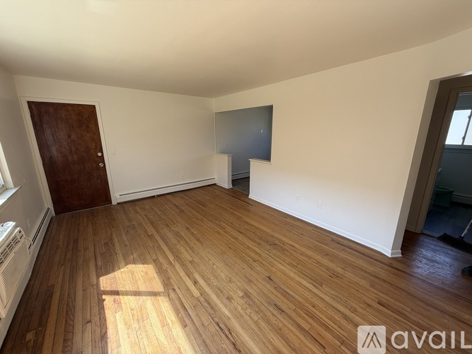 A room with wooden flooring and a brown door.