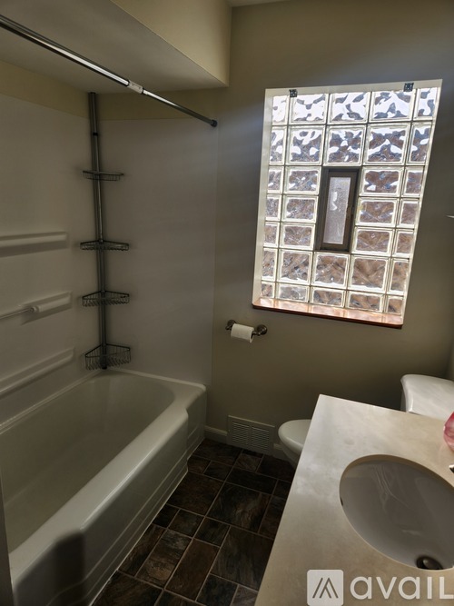 A bathroom with a tub, toilet, and sink.
