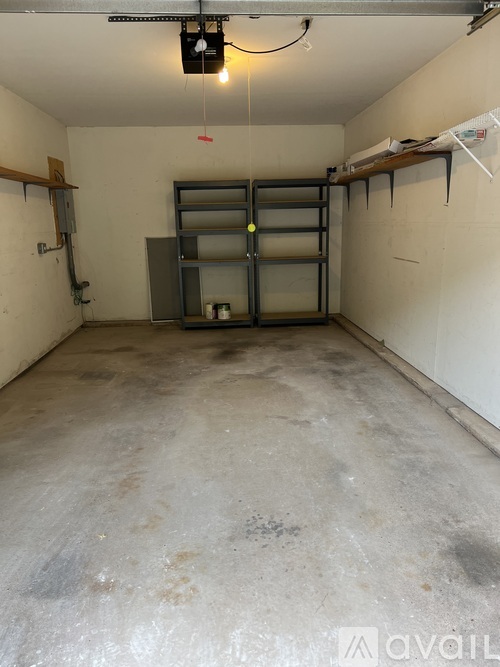 A storage room with a grey floor and a grey metal shelving unit.