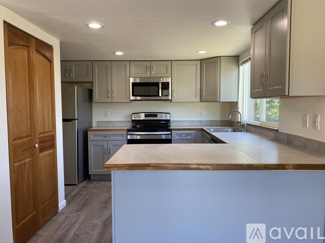 A kitchen with a white counter top and wooden cabinets.