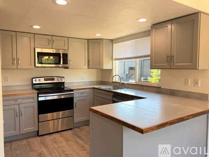 A kitchen with a stove top oven and a microwave above the stove.
