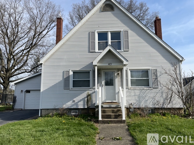 A two-story house with a white front door and a small porch.
