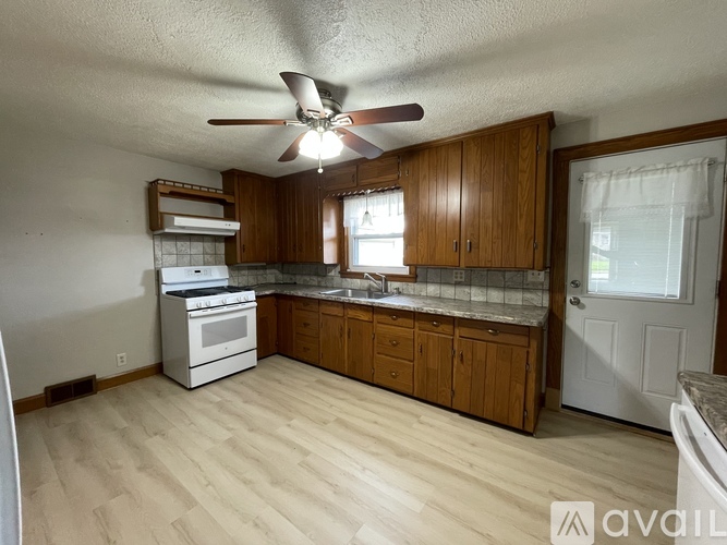 A kitchen with wooden cabinets and a white oven.