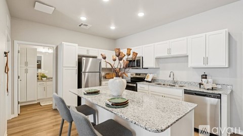 A kitchen with a marble countertop and stainless steel appliances.