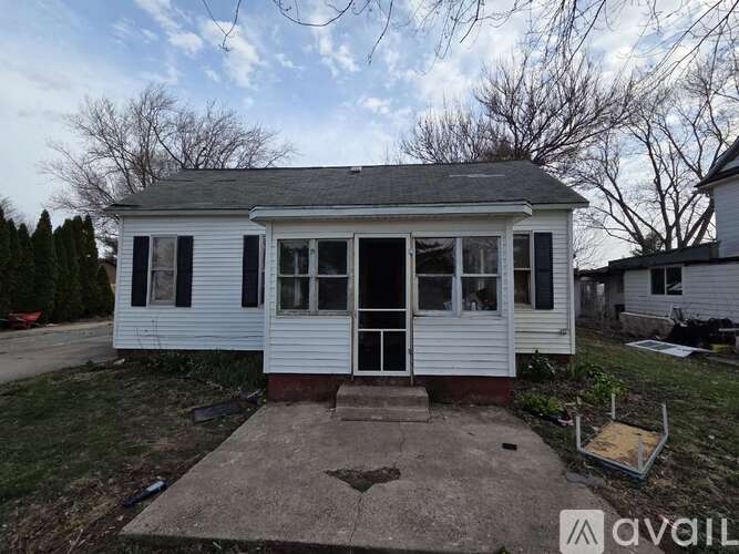 A small white house with a porch and a covered entrance.