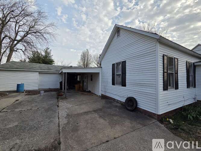 A white house with a garage is available for rent.