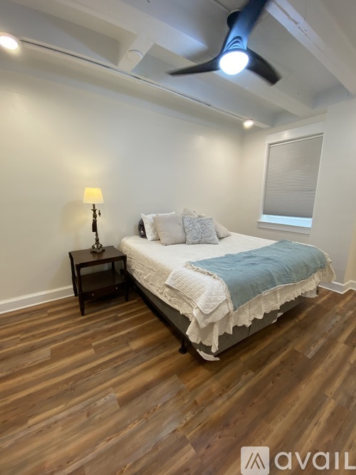 A bedroom with a bed, nightstand, and a ceiling fan.