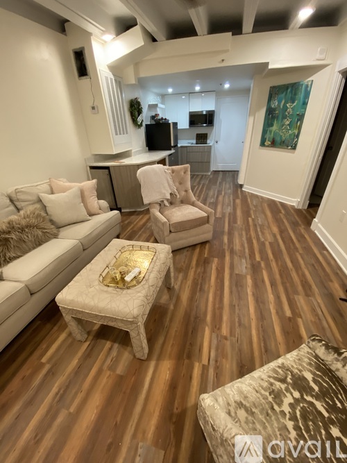 A living room with a white couch and a wooden floor.