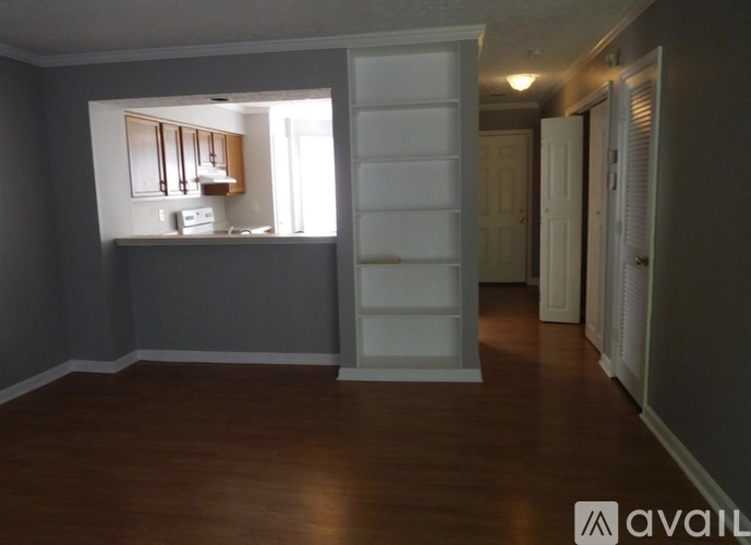 A room with a kitchenette and a white cabinet with a sliding door.