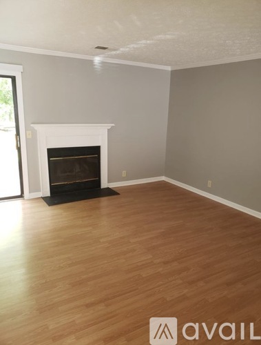 A room with a fireplace and wooden flooring.
