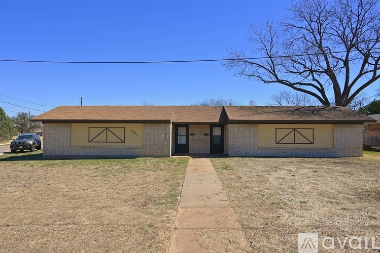 A small building with a brown roof and a tree in front of it.