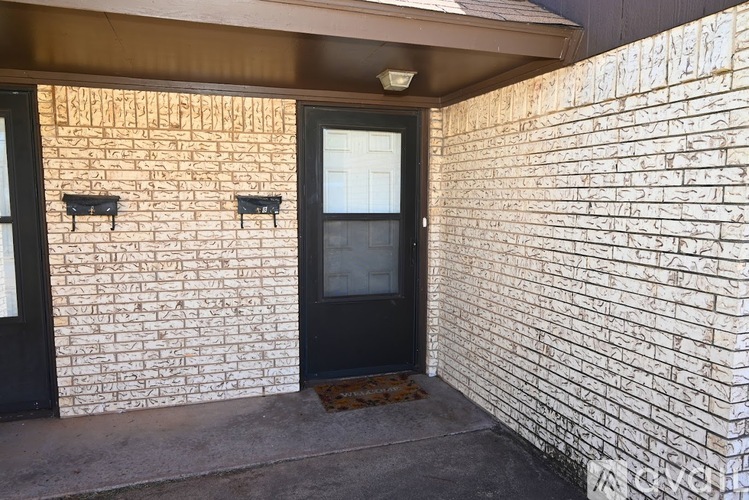 A black door is on the right side of a white brick wall.