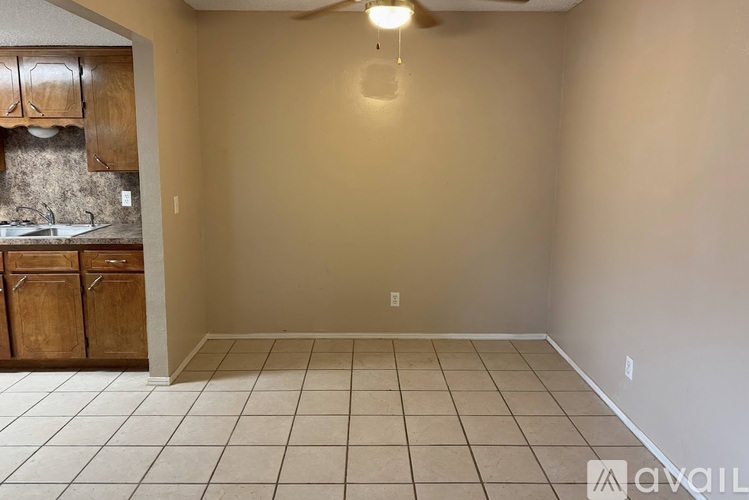 A kitchen with wooden cabinets and a tiled floor.