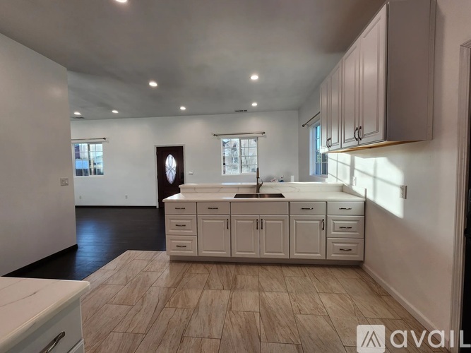 A kitchen with a sink, cabinets, and a window.