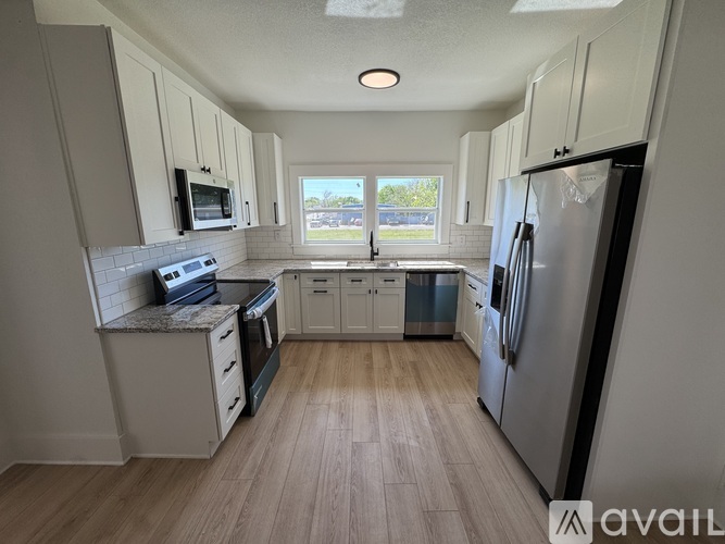 A kitchen with white cabinets and a large island.