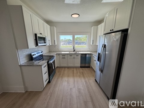 A kitchen with white cabinets and a large island.