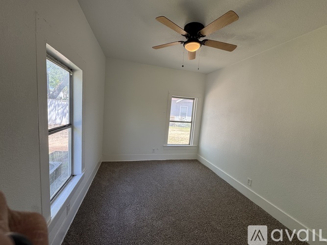 A room with a ceiling fan and a window.