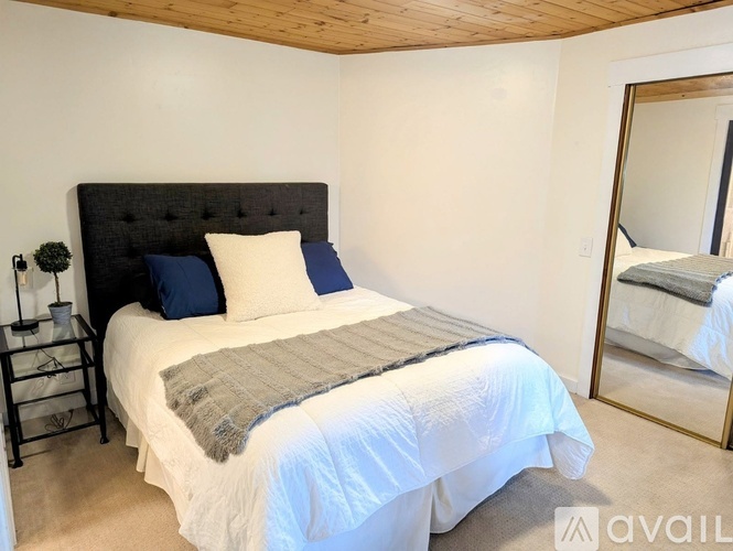 A bedroom with a large bed and a mirror on the wall.