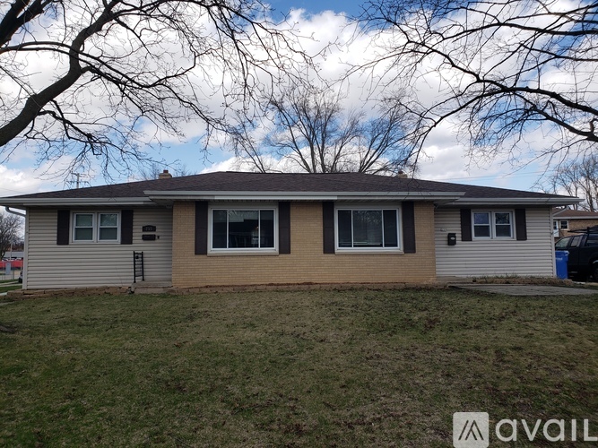 A house with a brown roof and beige siding is for sale.