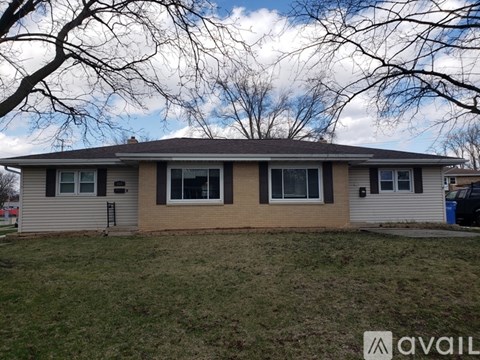 A house with a brown roof and beige siding is for sale.